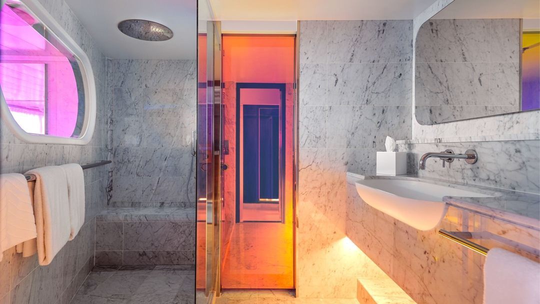 Seriously Suite marble bathroom with a glass-enclosed rainshower.